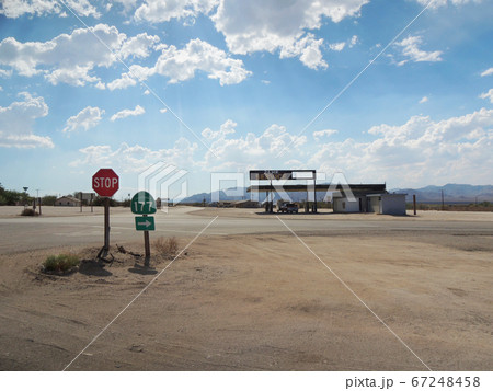 Beautiful sky over two sign poles & a gas station 67248458