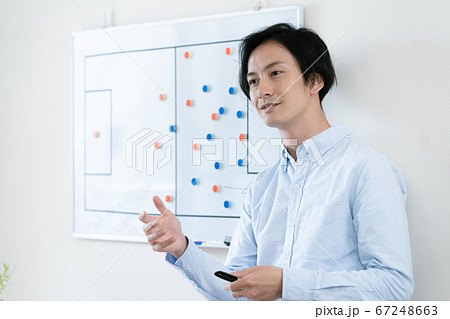 戦術を伝えるコーチの男性 67248663