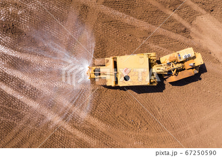 Articulated Water Truck spraying water, Aerial image. Articulated Water Truck spraying water, Aerial image. 67250590