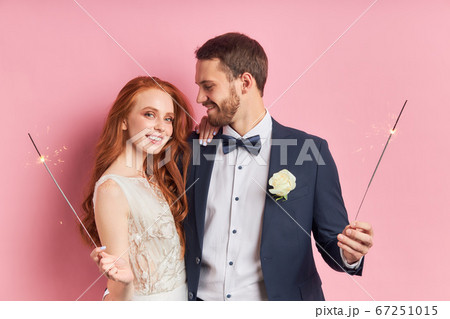 Young caucasian couple with bengal fire isolated over pink background 67251015