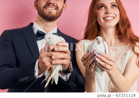 Newly-married happy couple holds doves 67251119