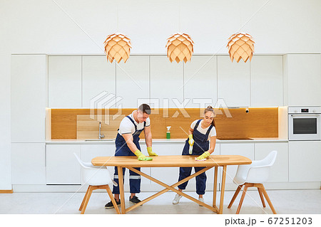 Housekeeping team cleaning kitchen table 67251203