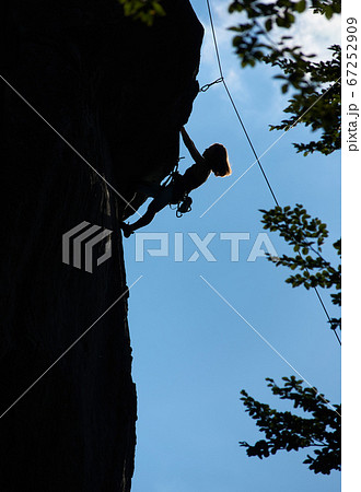 Female climber ascending mountain at night. 67252909