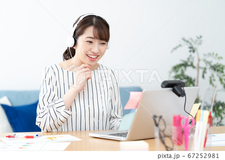 テレワーク 自宅で白いヘッドフォンをつけてウェブ会議をする若い女性 テレワーク 自宅で白いヘッドフォンをつけてウェブ会議をする若い女性 67252981