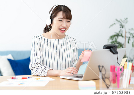 テレワーク 自宅で白いヘッドフォンをつけてウェブ会議をする若い女性 テレワーク 自宅で白いヘッドフォンをつけてウェブ会議をする若い女性 67252983