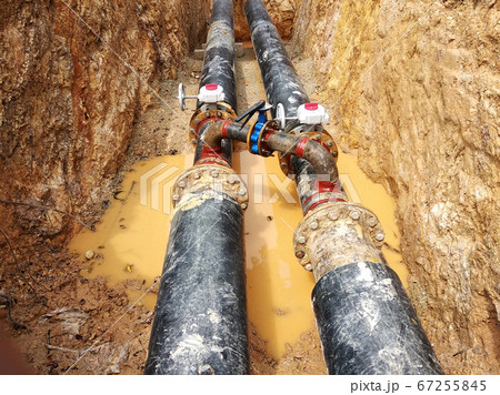 KUALA LUMPUR, MALAYSIA -JUNE 02, 2017: Underground utility and services pipe laid by workers in the trenches at the construction site. Installation of stop cork valve and joint in progress. KUALA LUMPUR, MALAYSIA -JUNE 02, 2017: Underground utility and services pipe laid by workers in the trenches at the construction site. Installation of stop cork valve and joint in progress. 67255845