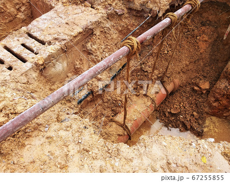 KUALA LUMPUR, MALAYSIA -JUNE 02, 2017: Underground utility and services pipe laid by workers in the trenches at the construction site. Installation of stop cork valve and joint in progress.    67255855