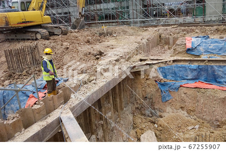 KUALA LUMPUR, MALAYSIA -JUNE 29, 2017: Construction workers spraying the anti termite chemical treatment to the soil at the construction site. KUALA LUMPUR, MALAYSIA -JUNE 29, 2017: Construction workers spraying the anti termite chemical treatment to the soil at the construction site. 67255907