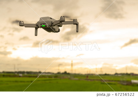 夕暮れの中、田んぼを空撮するドローン 夕暮れの中、田んぼを空撮するドローン 67256522