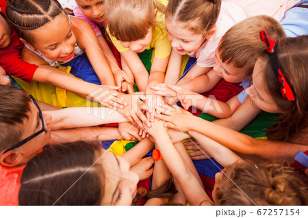 Children holding hands together, laying on a floor 67257154