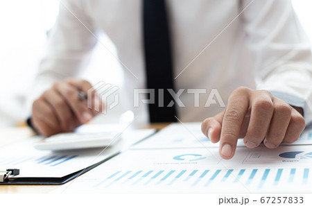 Business men use calculators to calculate the company's tax and revenue in the office, Financial and accounting banking concepts. Business men use calculators to calculate the company's tax and revenue in the office, Financial and accounting banking concepts. 67257833