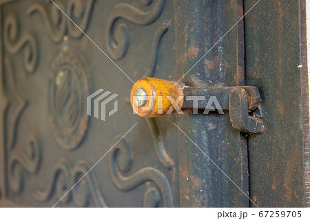 The wooden handle of a wood burning stove door, with details engraved on the stove door 67259705