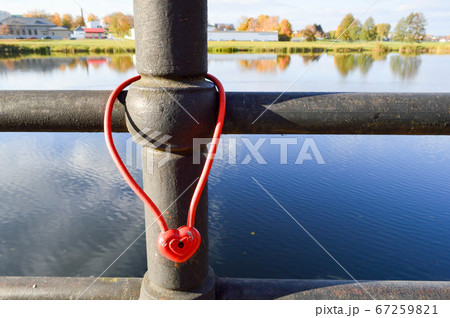 A red barn lock in the shape of a heart hangs A red barn lock in the shape of a heart hangs 67259821