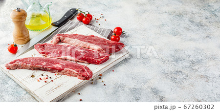 Raw steak with spices on wooden cutting board Raw steak with spices on wooden cutting board 67260302