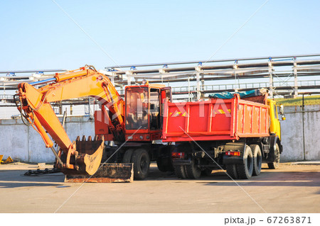 A large heavy yellow orange truck with a trailer 67263871
