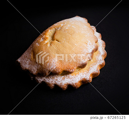 Sweet USSR soviet Russian nostalgic cottage cheese curd shortbread bun cookie Socknik. Pastry on dark grey black background. For thematic websites, magazine or food blog recipes, bakery advertising. 67265125