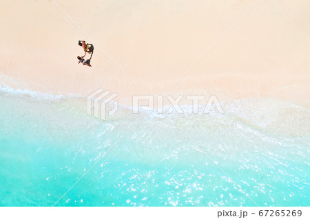 A couple walks along the Beach of Mauritius in the Indian ocean. Top view of the beach with turquoise water on the tropical island of Mauritius.Aerial photography, 67265269