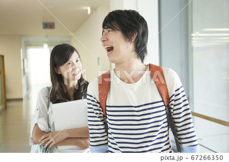 大学の廊下を歩く大学生カップルの写真素材