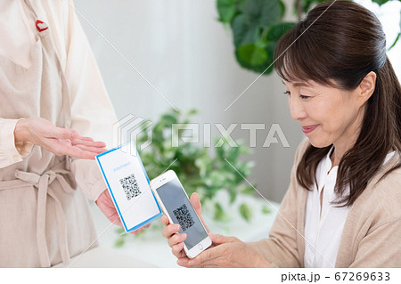 QRコードで決済するミドル女性 67269633