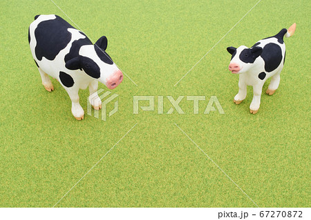 芝生にたたずむ牛の親子の粘土人形の写真素材