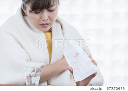 薬を飲む女性 67270976