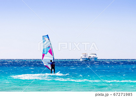 surfer rides in the Red Sea against the backdrop of two ships in Egypt Dahab 67271985