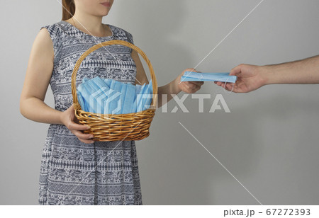 girl holds a basket with medical masks. girl holds a basket with medical masks. 67272393