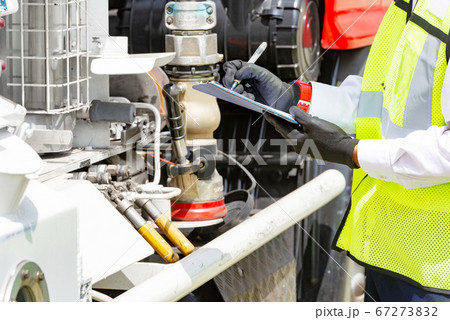 An officer with clipboard checking truck engine An officer with clipboard checking truck engine 67273832