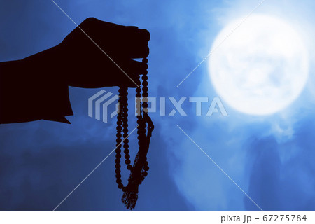 Silhouette of Muslim man praying with prayer beads 67275784