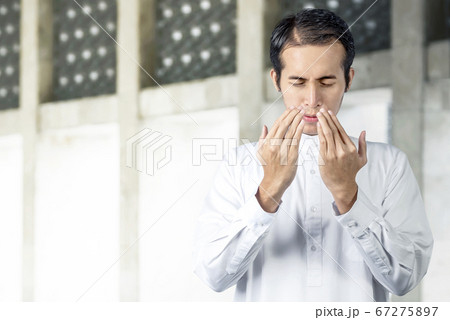 Asian Muslim man standing while raised hands and Asian Muslim man standing while raised hands and 67275897