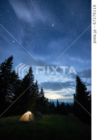 Magical starry night at a campsite in the mountains during summer time 67276119