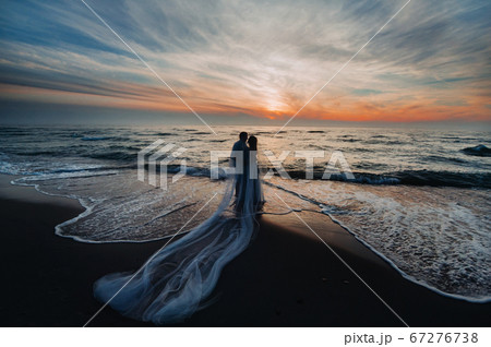 A couple in love at sunset on the background of the sea, an unrecognizable couple Portrait of a beautiful newlywed couple expecting a child. Photo, A couple in love at sunset on the background of the sea, an unrecognizable couple Portrait of a beautiful newlywed couple expecting a child. Photo, 67276738