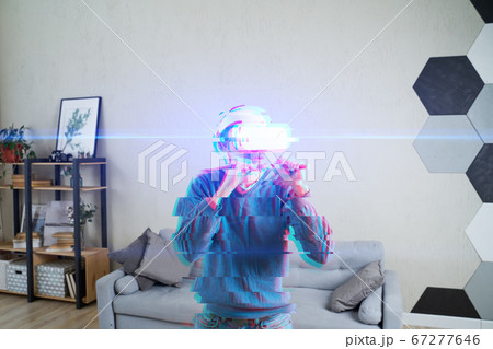 Man with virtual reality headset is playing game and fighting. Image with glitch effect. 67277646