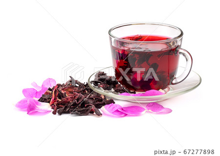 Hibiscus tea in glass cup among the rose petals. 67277898