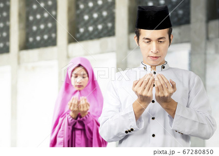 Asian Muslim couple standing while raised hands Asian Muslim couple standing while raised hands 67280850