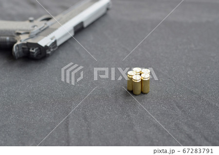9mm bullets and pistol lie on a black fabric. A 9mm bullets and pistol lie on a black fabric. A 67283791