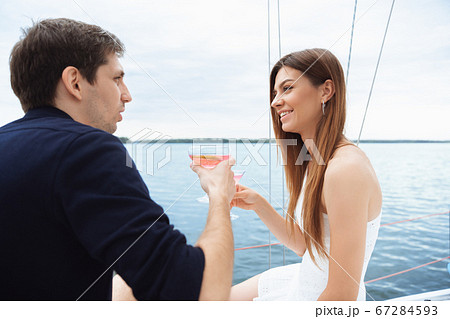Happy couple drinking vodka cocktails at boat party outdoor, cheerful and happy Happy couple drinking vodka cocktails at boat party outdoor, cheerful and happy 67284593