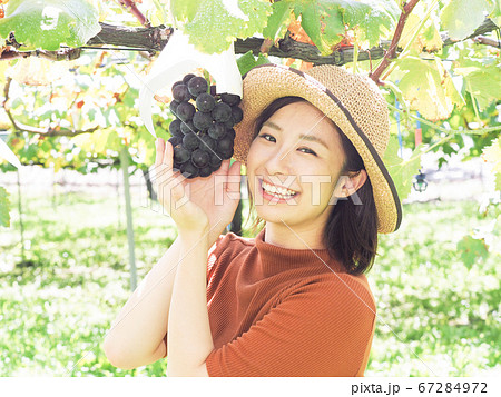 ぶどう園のぶどうに手を添える女性 67284972