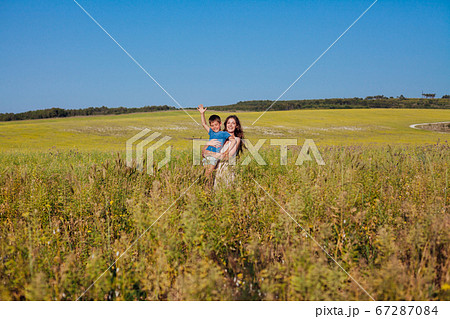 Portrait of a beautiful mom and son on a walk on nature field road 67287084