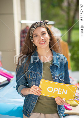 Positive happy woman holding an opening sign Positive happy woman holding an opening sign 67287497