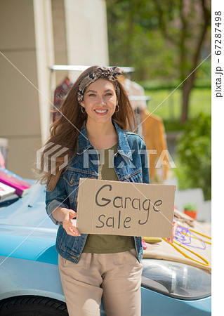 Positive long haired woman standing in front of her car Positive long haired woman standing in front of her car 67287498