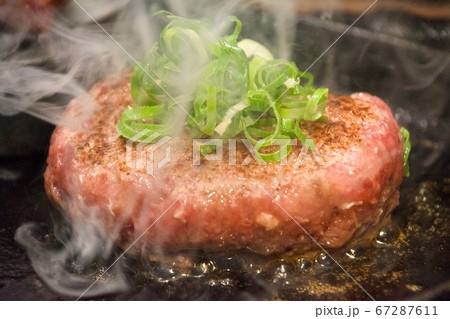熱々の鉄板の上で湯気の立ち上る、まだ半生のハンバーグ、たっぷりの刻みネギ。一人前。臨場感。大阪裏難波 67287611