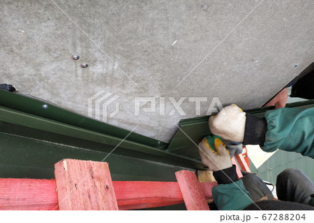 Workers line the chimney with green metal 67288204
