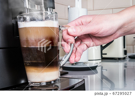 hand picks up a glass of hot cappuccino made 67295027