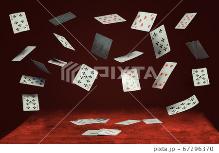 playing cards fly and fall on a table with red cloth playing cards fly and fall on a table with red cloth 67296370