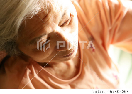 下を向いて黙々と何かをする白髪のシニア女性の写真素材