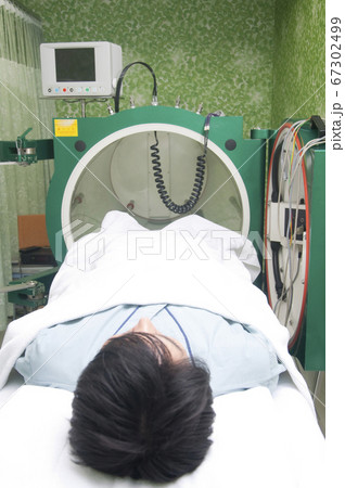 酸素カプセルに入る男性 67302499