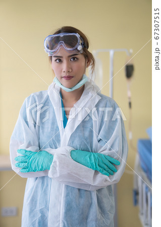 Smiling asian female doctor removing his surgical 67307515