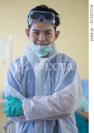 Smiling asian male doctor removing his surgical Smiling asian male doctor removing his surgical 67307516