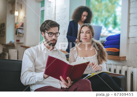 Guy with glasses with book and two girls. Guy with glasses with book and two girls. 67309455